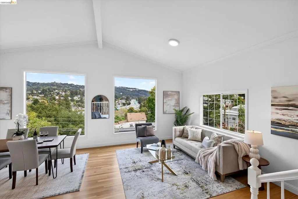 Vaulted ceilings with exposed beam, expansive windows, recessed lighting, and wood-finish flooring