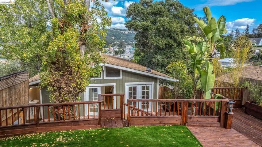 Expansive wood deck with a built-in planter, artificial turf area, and wood railings