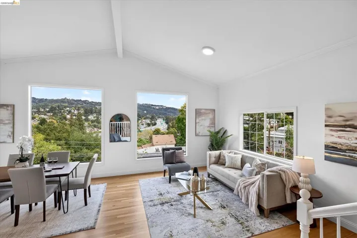 Vaulted ceilings with exposed beam, expansive windows, recessed lighting, and wood-finish flooring