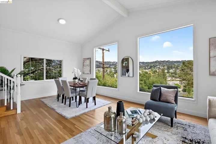 Vaulted ceilings with exposed beams, hardwood flooring, recessed lighting, expansive windows, and white painted balusters
