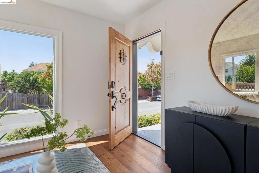Hardwood flooring, custom entry door with decorative hardware, wide window frame, and built-in storage cabinet Hardwood flooring, custom entry door with decorative hardware, wide window frame, and built-in storage cabinet