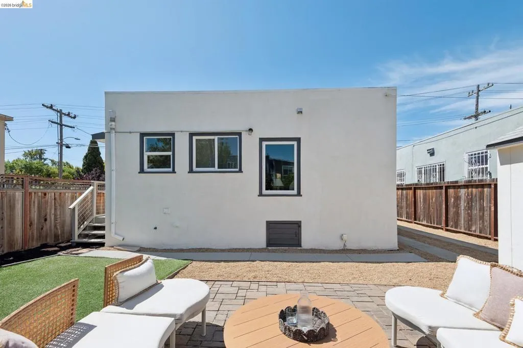 Private patio area featuring a paver stone surface, artificial turf, and gravel landscaping Private patio area featuring a paver stone surface, artificial turf, and gravel landscaping