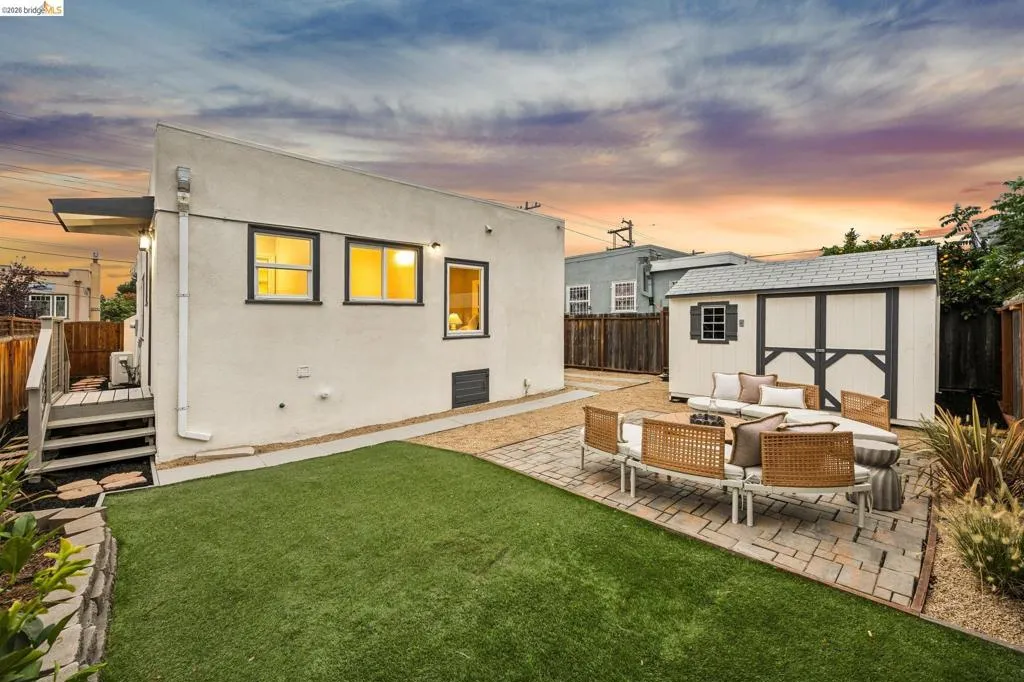 Expansive yard featuring artificial turf, a paver patio, gravel landscaping, and a detached storage shed Expansive yard featuring artificial turf, a paver patio, gravel landscaping, and a detached storage shed
