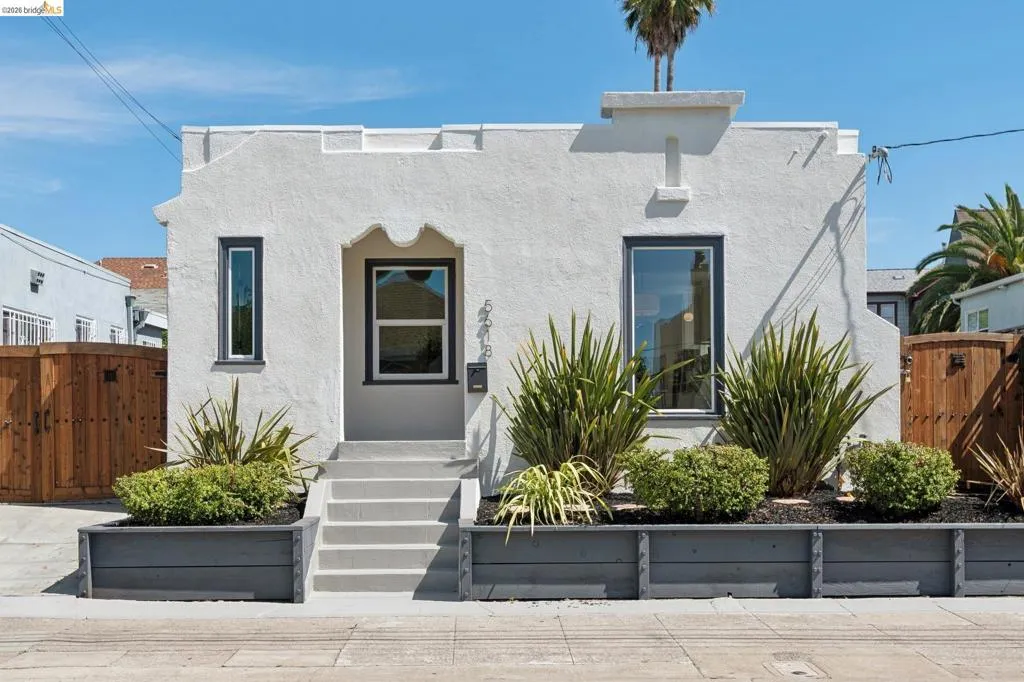Stucco exterior with decorative parapet, contrasting trim windows, and a multi-step entry Stucco exterior with decorative parapet, contrasting trim windows, and a multi-step entry