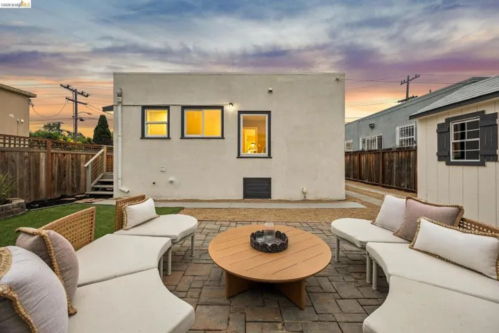 Paver patio area, gravel landscaping, stucco exterior, privacy fencing, manicured lawn