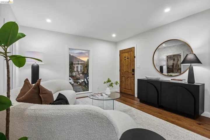 Hardwood flooring, recessed ceiling lighting, a wood-finish entry door, and a built-in console cabinet