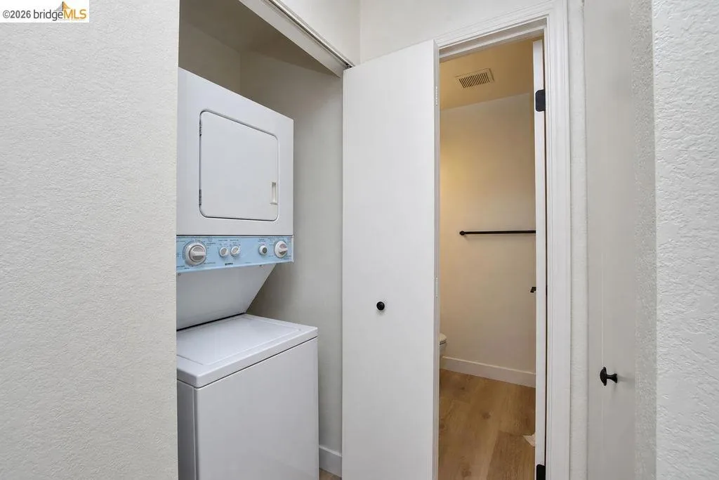 Integrated stacked laundry appliances within a dedicated utility closet