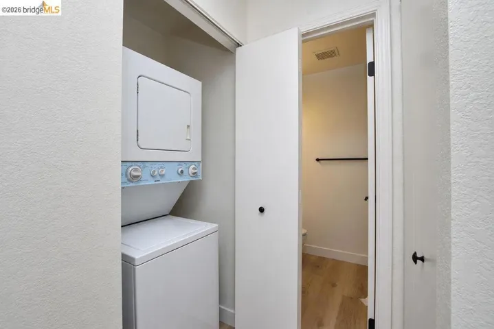 Integrated stacked laundry appliances within a dedicated utility closet