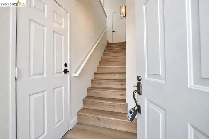 Wood-finish stairs with a white handrail, framed by two panel doors