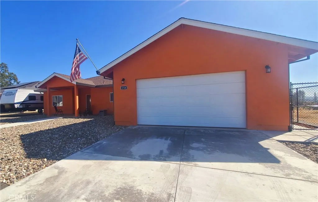 View of driveway area leading to garage with side access gate on the right. View of driveway area leading to garage with side access gate on the right.