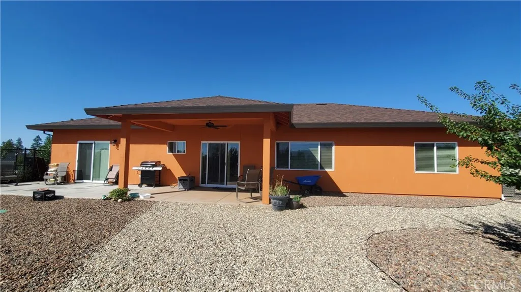 View of the back of home with covered patio, easy maintenance landscape and garden area to the right. View of the back of home with covered patio, easy maintenance landscape and garden area to the right.