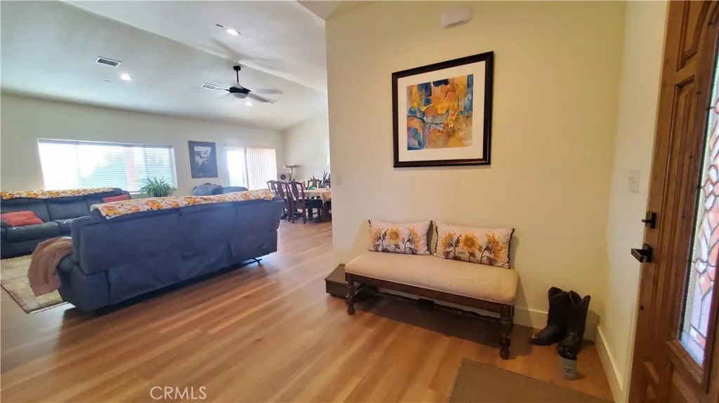 View of front entry with open living room, vaulted ceilings, large window & sliding glass door facing the covered back patio area. View of front entry with open living room, vaulted ceilings, large window & sliding glass door facing the covered back patio area.