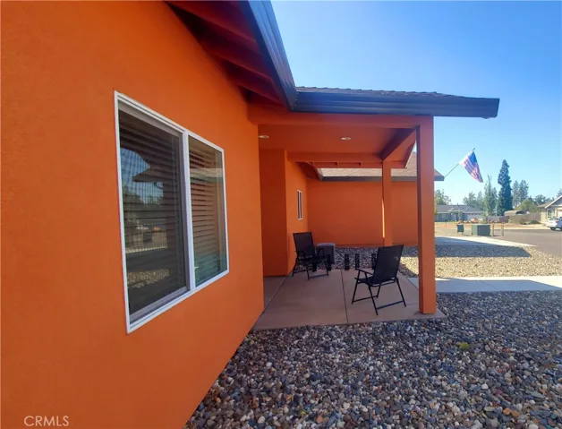 View of covered front patio with concrete side walk leading to circle driveway.