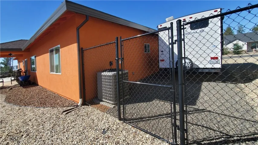 View of side yard with RV parking and access gate to back yard.