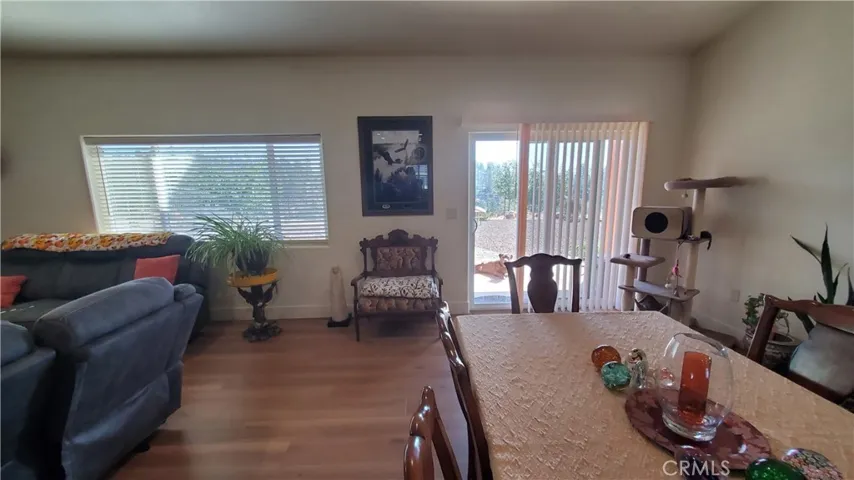 View of living room area with large picture window and sliding glass door leading to covered back patio.