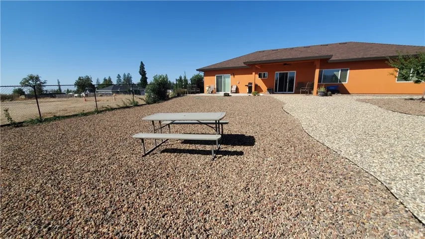 View from fenced back yard of the back side of the home with sliding glass doors to living room and master bedroom.
