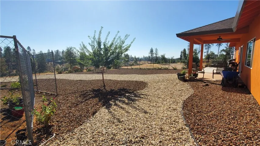 View of back yard with garden area and covered back patio.