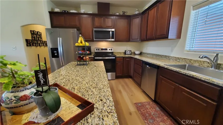 View along kitchen island with kitchen sink to the right with kitchen window overlooking front yard.
