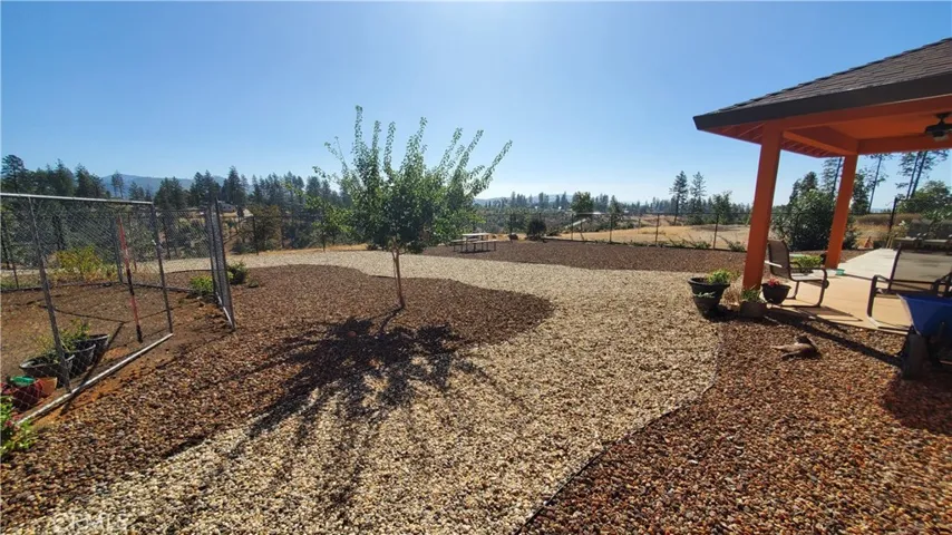 View of fenced back yard area with covered back patio.