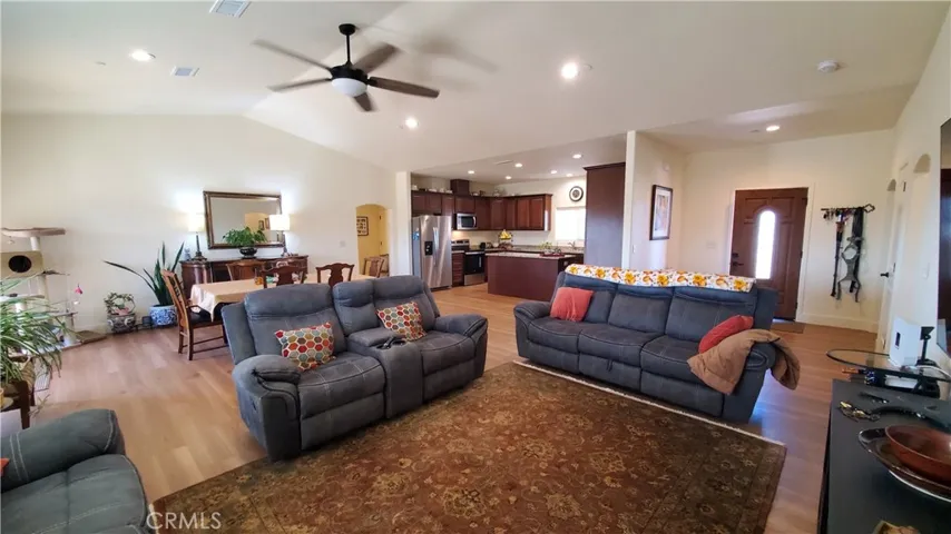 View of living room with vaulted ceilings, open to the front entry and kitchen area.