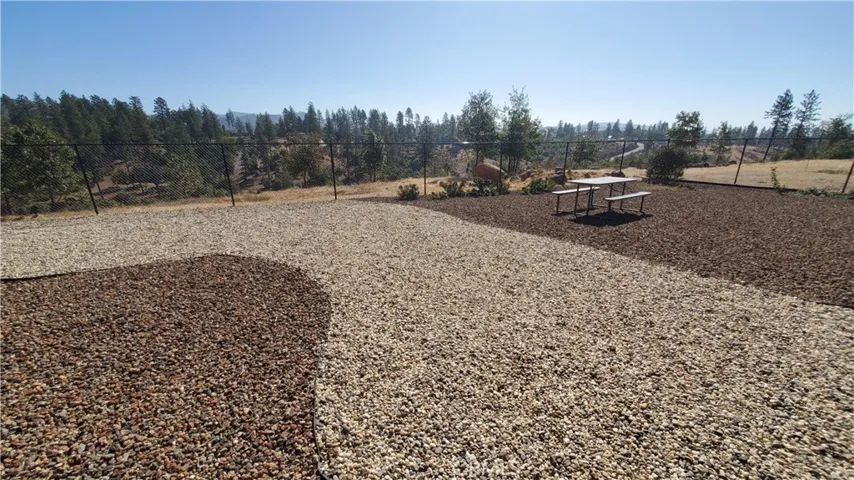 View of fully fenced back yard with low maintenance landscaping.