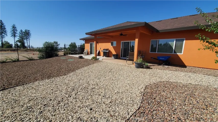 View of back yard area with covered back patio area with sliding glass doors to the living room and master bedroom.