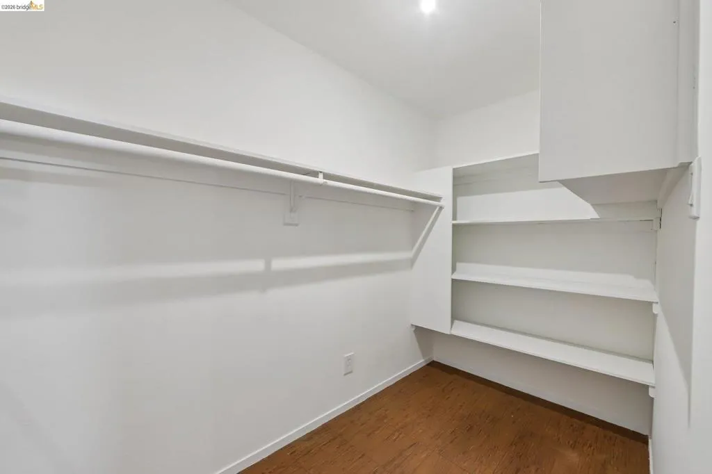 Built-in shelving, hanging rod, and wood-finish flooring