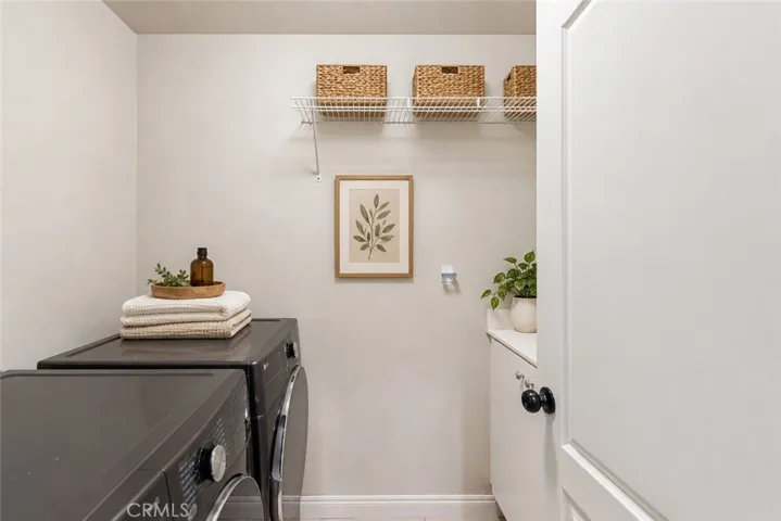 Virtual stage. Downstairs inside laundry room w/utility sink and cabinet storage.