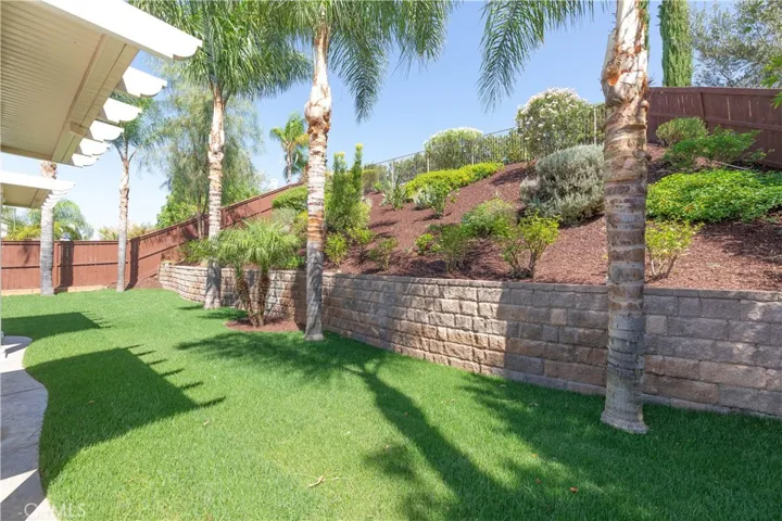 New grass. Nice retaining wall with manicured slope. Peaceful and private.