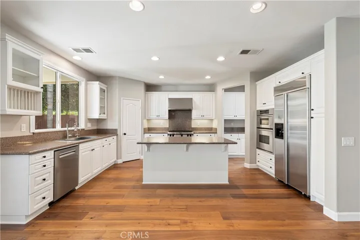 Kitchen w/pass-through butler's pantry, island w/breakfast bar, high-end stainless steel appliances.