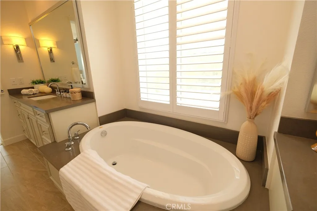 Oval bathtub positioned bedside bright windows for a relaxing bathing space. Oval bathtub positioned bedside bright windows for a relaxing bathing space.