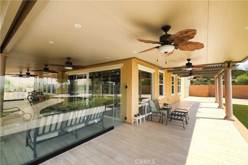 Spacious covered patio with seating areas and ceiling fans for comfortable outdoor gatherings. Spacious covered patio with seating areas and ceiling fans for comfortable outdoor gatherings.