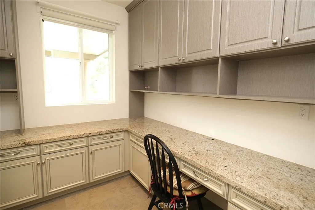 Built-in workspace featuring a long desktop, overhead cabinetry, and natural light. Built-in workspace featuring a long desktop, overhead cabinetry, and natural light.
