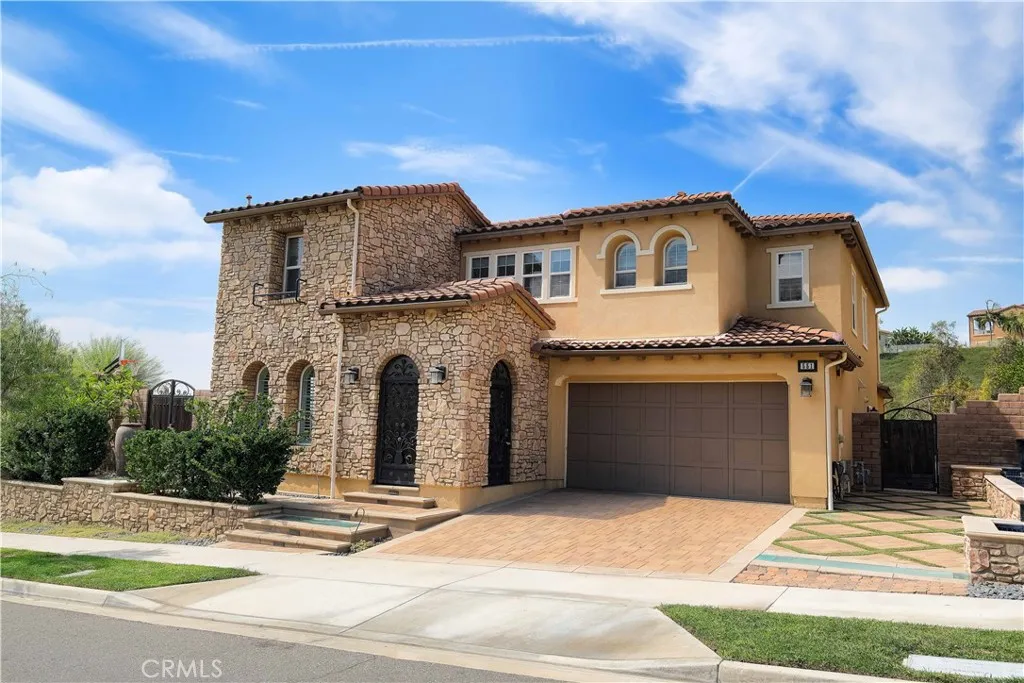 Closwer exterior view highlighting the arched doorway, textured architectural accents, and attached garage. Closwer exterior view highlighting the arched doorway, textured architectural accents, and attached garage.