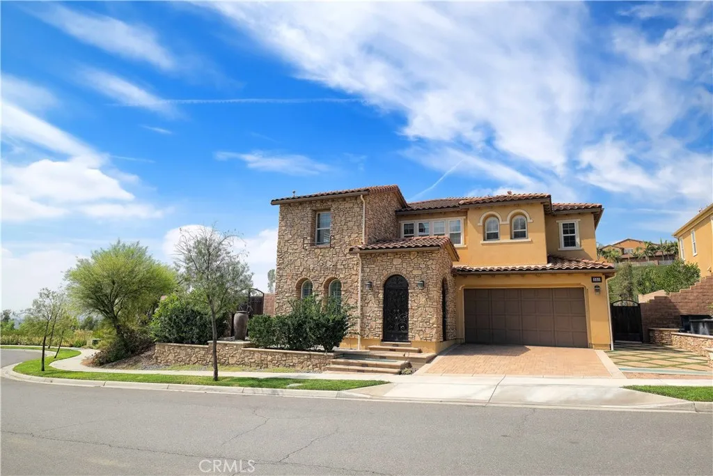 Inviting curb appeal with warm stucco finishes, tiled rooflines, and a paved driveway. Inviting curb appeal with warm stucco finishes, tiled rooflines, and a paved driveway.