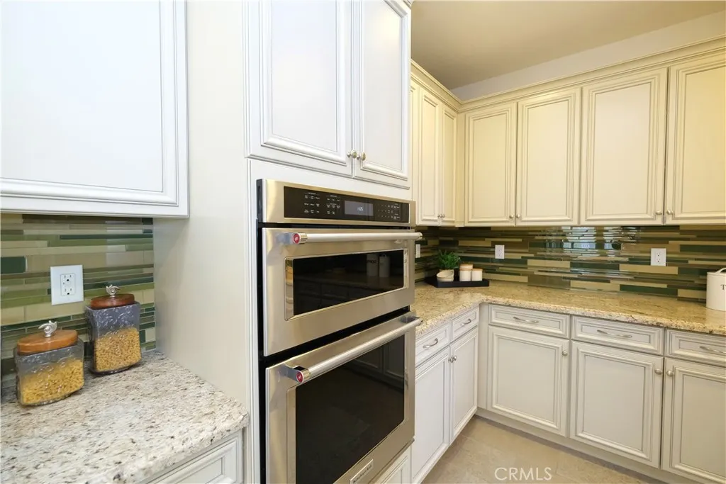 Built-in microwave and wall oven surrounded by ample cabinetry and countertop workspace. Built-in microwave and wall oven surrounded by ample cabinetry and countertop workspace.