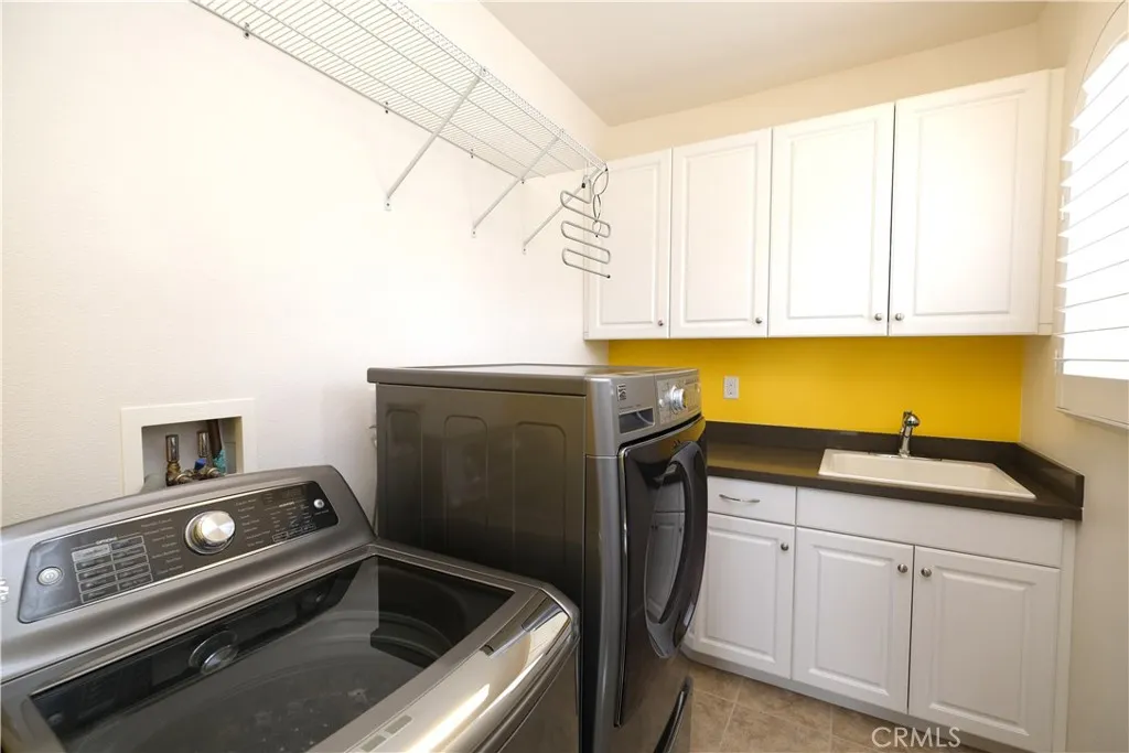 dedicated laundry room with side by side appliances, a utility sink, and ample cabinetry. dedicated laundry room with side by side appliances, a utility sink, and ample cabinetry.