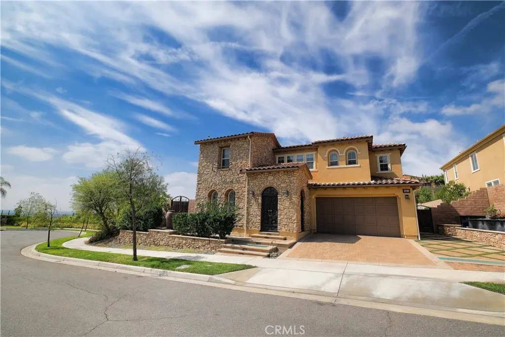 Mediterranean-inspired exterior featuring a tiled roof, arched entry, and warm-toned finishes. Mediterranean-inspired exterior featuring a tiled roof, arched entry, and warm-toned finishes.