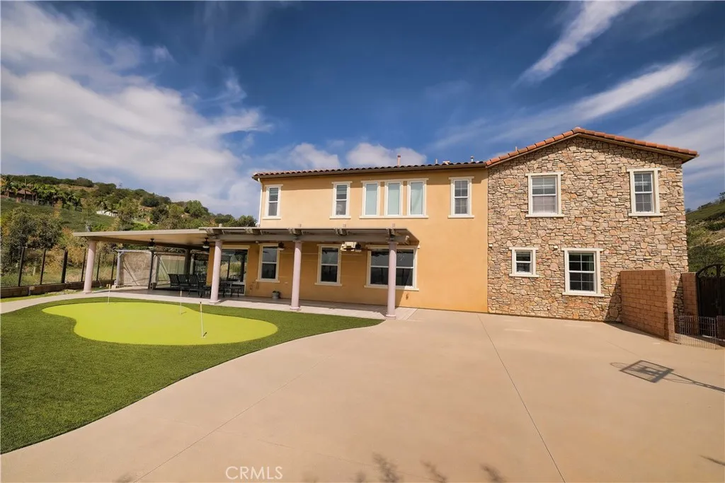 rear exterior showcasing the home's two-story design and extensive paved patio. rear exterior showcasing the home's two-story design and extensive paved patio.