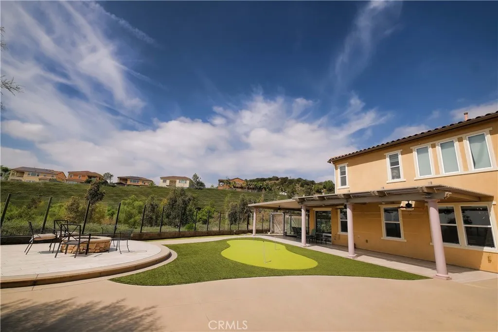 Inviting backyard with distinct recreation and seating areas against a backdrop of surrounding hills. Inviting backyard with distinct recreation and seating areas against a backdrop of surrounding hills.