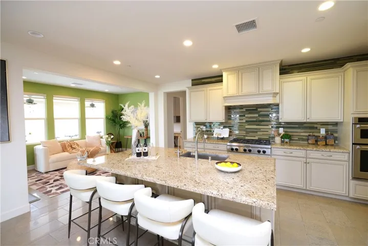 Spacious kitchen featuring a large center island, extensive cabinetry, and built-in appliances.
