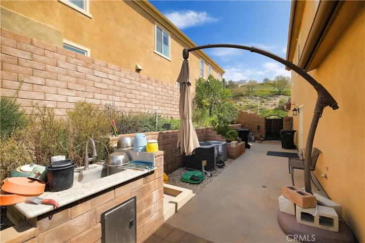 side patio featuring a countertop workspace and room for container gardening.