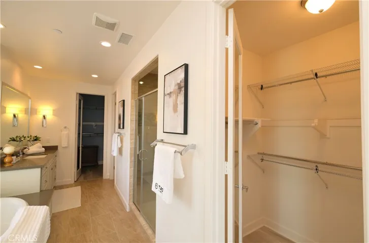 Bathroom storage detail featuring open shelving beside the vanity area.