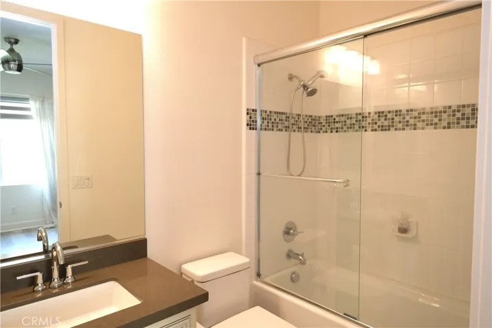 Another view of the bathroom, highlighting the vanity and decorative shower telework.