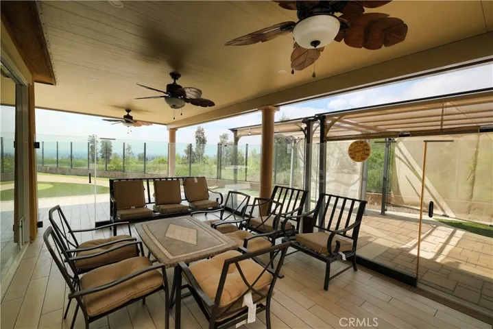 Covered patio with ceiling fans and views toward the outdoor surroundings.