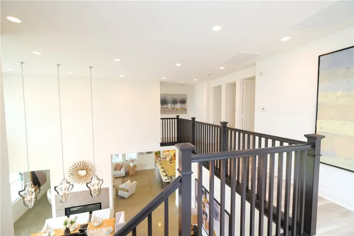 Open upper-level landing overlooking the soaring entry and dining area below.