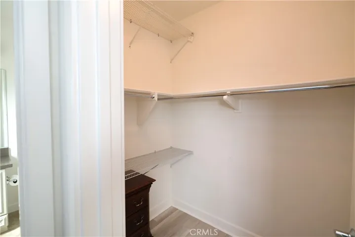 Walk-in closet with shelving and hanging rods for organized storage.