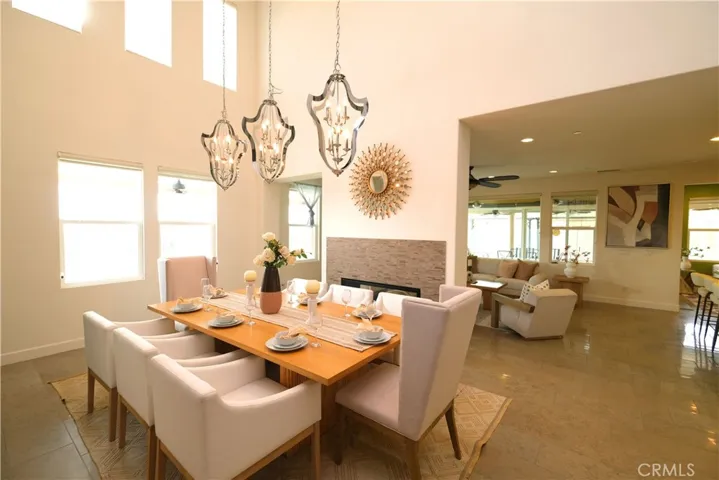 Dramatic dining room with soaring ceilings, upper windows, and statement chandeliers.