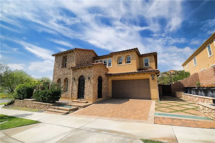 Front exterior highlighting the attached garage, paved driveway, and inviting entry.