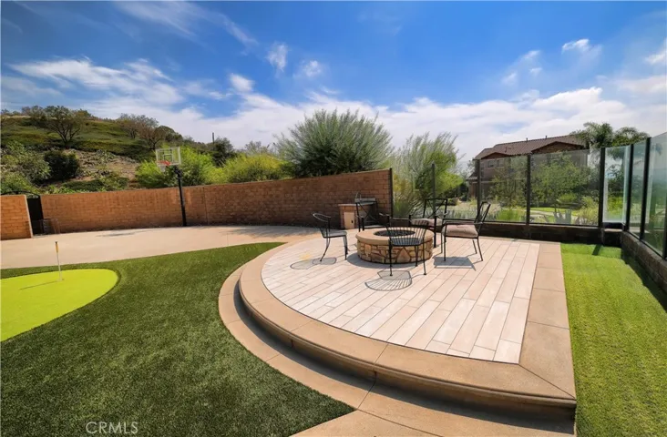 curved, raised patio creates a distinct gathering space beside the putting green.